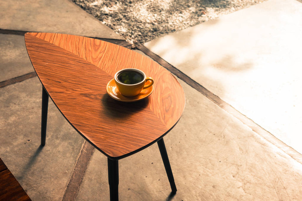 Café de filtro especial en taza amarilla en una mesa de madera en la cafetería hipster. Luz del sol. Efecto de filtro de color vintage. Copyspace; vertical - Foto, imagen