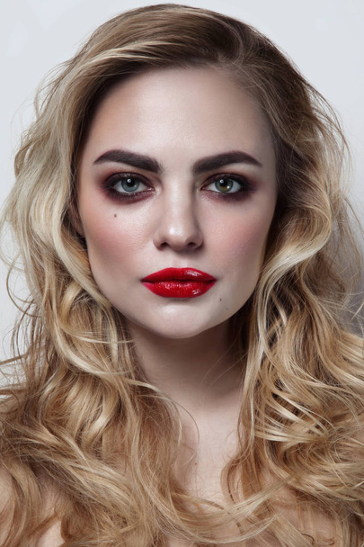Young beautiful woman with blonde curly hair and red lipstick - Fotó, kép