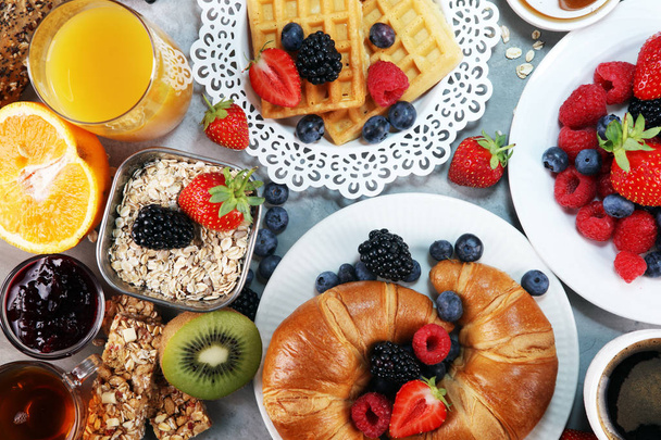 snídaně na stole s oplatky, croissanty, kávu a džus - Fotografie, Obrázek