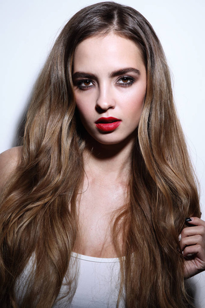 Young beautiful girl with long curly hair and red lipstick - Photo, image