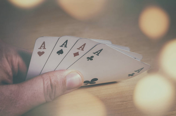 Παίζοντας χαρτιά. Τέσσερις άσους παίζοντας χαρτιά του πόκερ στο χέρι. - Φωτογραφία, εικόνα