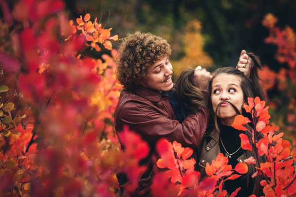 coppia allegra è cattivo e mostra emozioni tra alberi rossi autunno
 - Foto, immagini