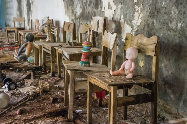 ένα παιχνίδι κούκλα μωρό κάθεται σε ένα κρεβάτι σε ένα εγκαταλελειμμένο Νηπιαγωγείο κτίριο κοντά Pripyat, το Τσερνομπίλ στην Ουκρανία - Φωτογραφία, εικόνα