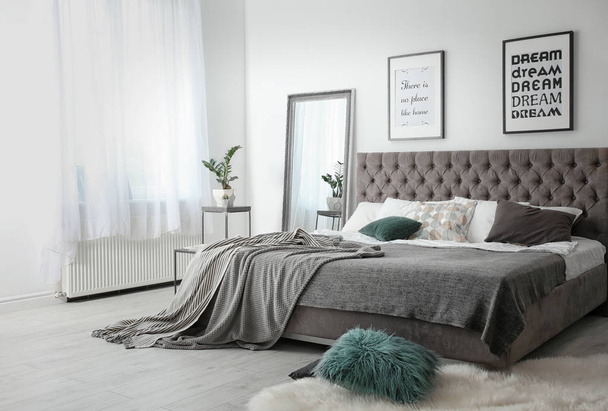 Elegant room interior with large comfortable bed - Фото, зображення