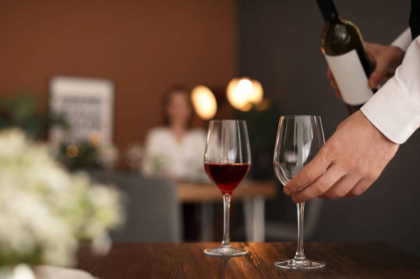 Man pouring wine into glass in restaurant - Foto, imagen