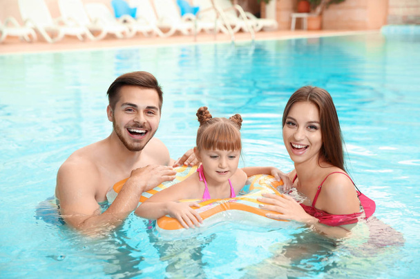 Happy family with inflatable ring in swimming pool - Fotografie, Obrázek