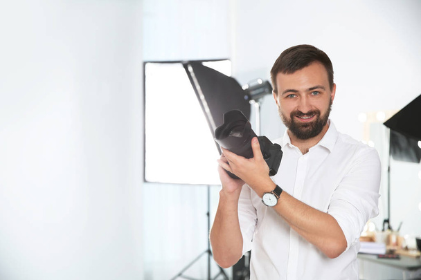 Professional photographer with camera in photo studio - Photo, image