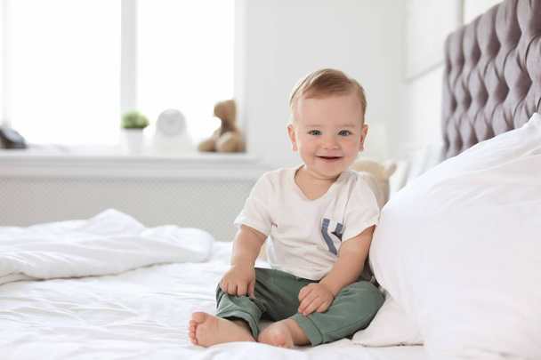 Adorable little baby sitting on bed at home - Foto, Imagen