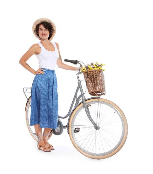 Portrait of beautiful young woman with bicycle on white background - Фото, изображение