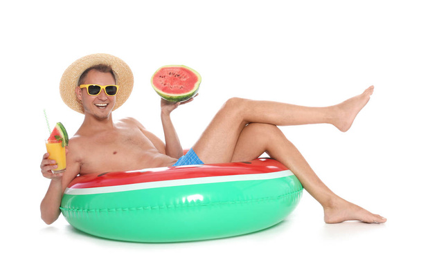 Shirtless man with inflatable ring, watermelon and glass of cocktail on white background - 写真・画像