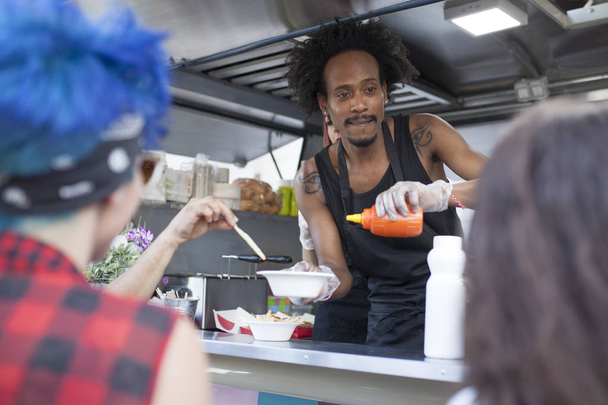 śmieszne i młody człowiek afro na food truck - Zdjęcie, obraz