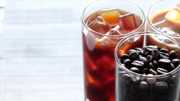 Fekete jeges kávét, hideg latte és bab táblázat felett - Felvétel, videó