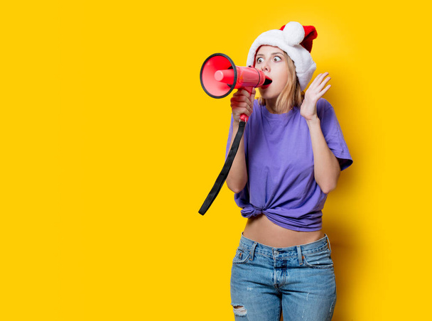 Młoda dziewczyna w purpurowym ubraniu i Boże Narodzenie kapelusz z różowym megafonem na żółtym tle. Symbolizuje kobiecy opór. Ubrania w stylu lat 80. - Zdjęcie, obraz