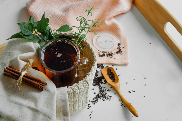 Transparent Cup of tea brewed with adjacent wooden spoons. Cinnamon sticks. Tea time. Tea leafs, Flat Lay - Фото, зображення