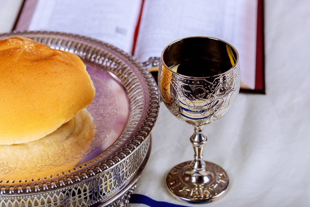 Lähikuva leipää ja kuppi punaviiniä piikki puinen pöytä ehtoollinen, kristillinen käsite muistutus Jeesuksesta
 - Valokuva, kuva