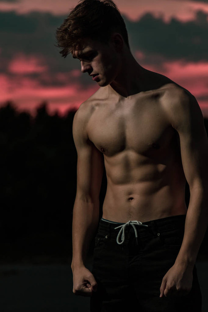 Young adult male posing shirtless at sunset - Foto, Bild