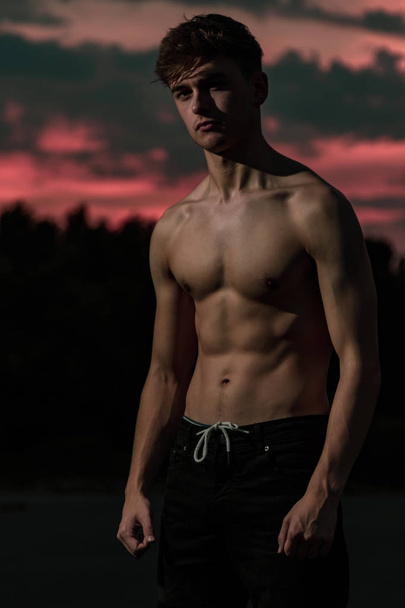 Young adult male posing shirtless at sunset - Valokuva, kuva