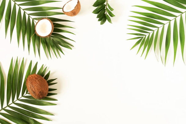 Travel background. Frame made of tropical green palm leaves and coconuts on white background. Flat lay, top view, copy space - Foto, afbeelding
