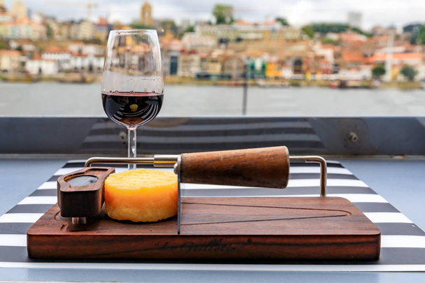 Ποτήρι κρασί Πόρτο και το τυρί με θολή αστικό τοπίο του Πόρτο Πορτογαλίας στο παρασκήνιο - Φωτογραφία, εικόνα