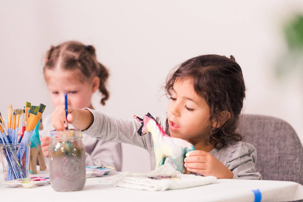Bambine che decorano piccole figurine di unicorno di cartapesta
. - Foto, immagini