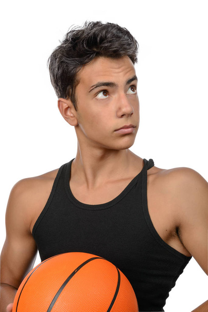 Portrait of a young basketball player passing the ball. Young caucasian boy in sportswear playing basketball on white background with copyspace - Φωτογραφία, εικόνα