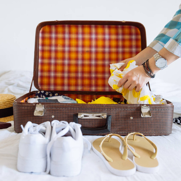 γυναίκα χέρια με ρολόι θέσει ρούχα στη βαλίτσα. έννοια του ταξιδιού. χώρο αντίγραφο - Φωτογραφία, εικόνα