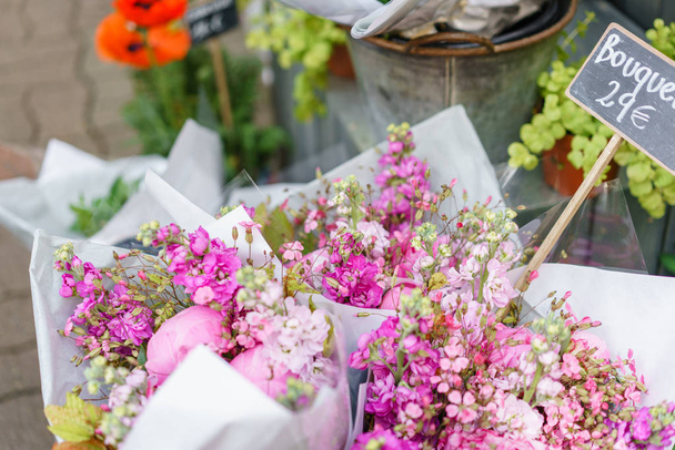 beautiful bouquet in flower shop. outdoor working in flower shop. assistant in floral design studio, making decorations and arrangements. - Photo, Image
