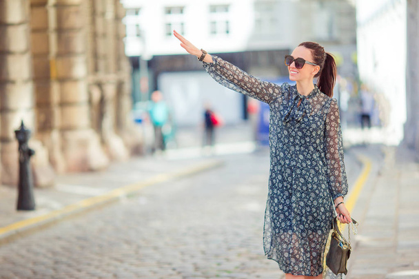 Uma mulher a andar na cidade. Jovem turista atraente ao ar livre na cidade europeia
 - Foto, Imagem
