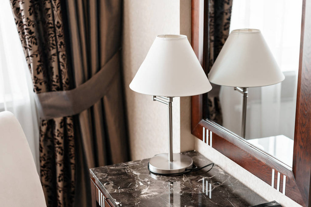 belső hotel apartman, szoba, tükör és íróasztal. a megjegyzéseket és a lámpa állva egy szállodai szobában egy asztal mappa - Fotó, kép
