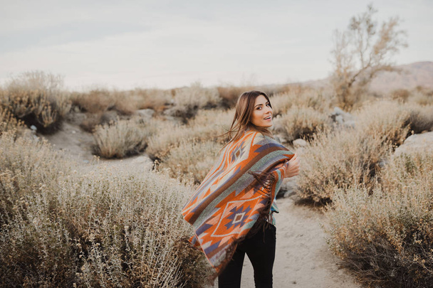 Boho nő szeles hajszárítóval, a sivatagi jellegű, fordult a fejét, és mosolygott, a kamera hátoldalán. Művészi fénykép cigány fiatal csípő utazó lány néz ki, a Coachella völgyben egy sivatagi völgyben, Dél-Kaliforniában. - Fotó, kép