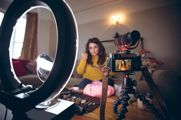 Женский видео регистратор применяет макияж дома
 - Фото, изображение