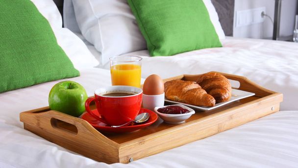 ホテルの部屋のベッドでトレイで朝食。.  - 写真・画像