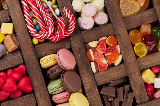 Caja de dulces de colores. Piruletas, macarrones, malvavisco, mermelada y caramelos. Vista superior
 - Foto, imagen