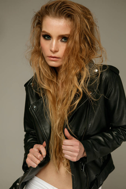 Female fashion model wearing grunge style clothes posing on studio background - Foto, imagen