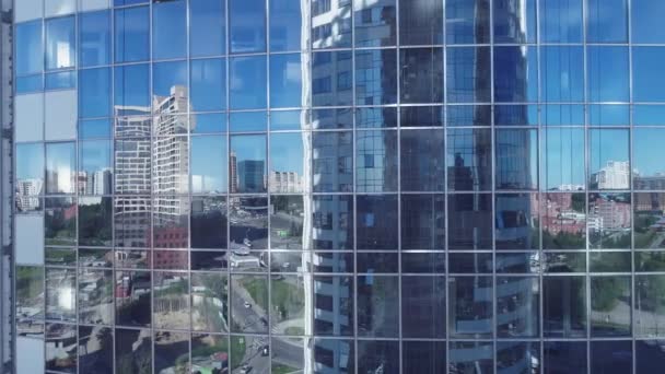 企業の建物の窓に反射。ビジネス センターの空撮。高層ビルの正面に飛んでカメラ。ショットに近い高層ビル - 映像、動画