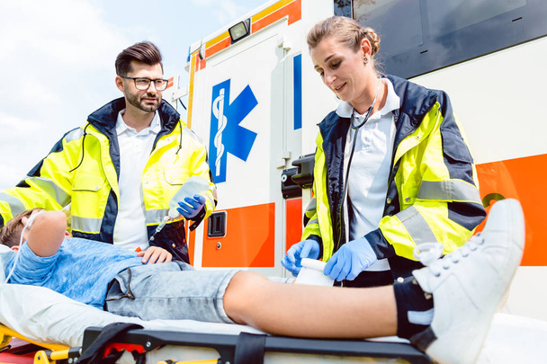 Médico paramédico y de emergencia que atiende a un niño herido
  - Foto, imagen