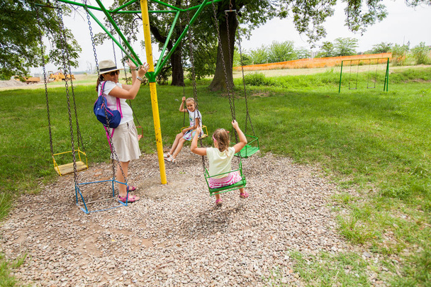 Madre e figlie buon divertimento in estate parco a giostra swing
 - Foto, immagini