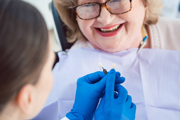 Zahnärztin führt Zahnbleichen bei Seniorin durch  - Foto, Bild