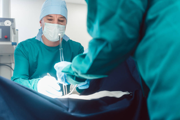 Lékaři a chirurgové působí pacientovi v nemocnici - Fotografie, Obrázek