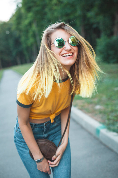 Young stylish cheerful woman walking in park  - Фото, зображення