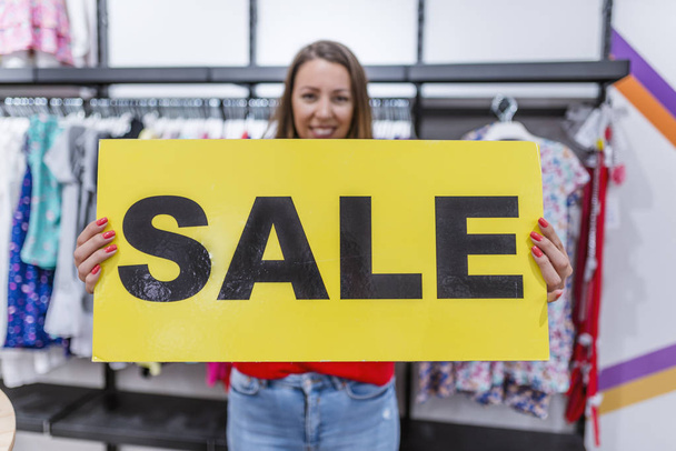 Woman holding sign of a sale. Store discount sign. Sale sign. Sale concept. Shopping sales.  Women like sales. Love sales - Fotoğraf, Görsel