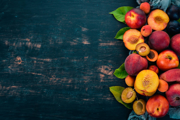 Fresh fruits. Apricot, peach, plums, nectarines. On a wooden background. Top view. Free space for your text. - Φωτογραφία, εικόνα