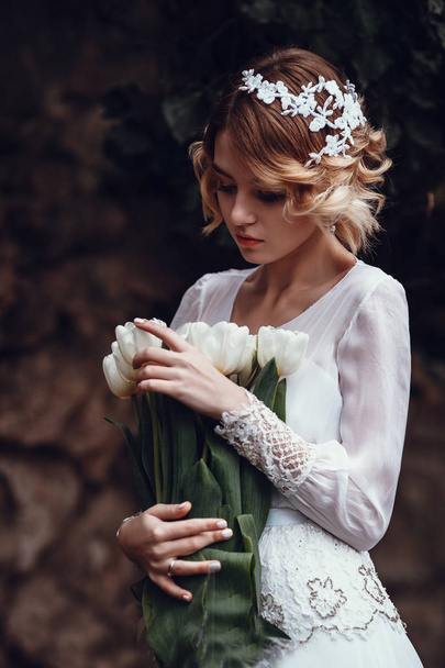 Młody piękny blond kobieta stwarzających z kwiatów - Zdjęcie, obraz