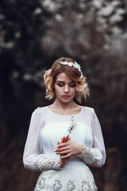 Jeune belle femme blonde posant avec des fleurs
 - Photo, image