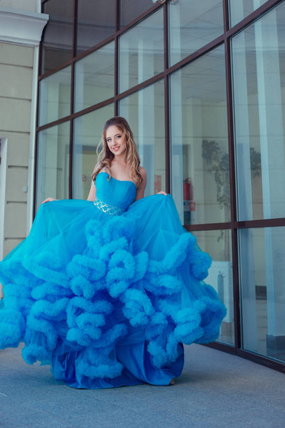 Όμορφο νεαρό μοντέλο με ένα μπλε φόρεμα που παρουσιάζουν  - Φωτογραφία, εικόνα