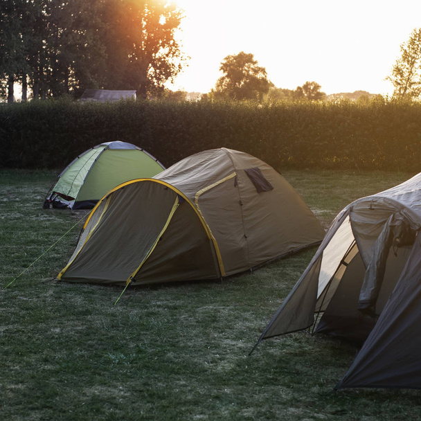 Toeristische tenten kamperen op een prachtige vroege zomeravond - Foto, afbeelding