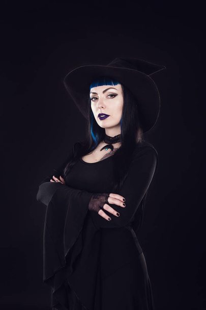 Ведьма Хэллоуина. Красивая молодая женщина в колпаке и костюме ведьмы. Хелоуинский дизайн
 - Фото, изображение