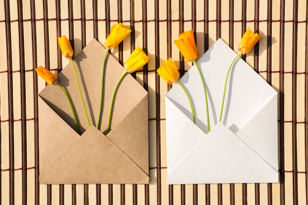 Enveloppe de papier kraft avec un message vierge et de belles fleurs orange
 - Photo, image