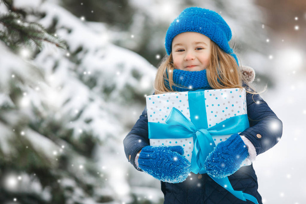 Adorable niño con regalos de Navidad al aire libre
 - Foto, Imagen