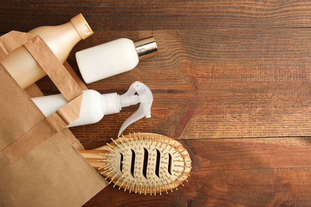 Moyens pour le soin des cheveux dans un emballage sur un fond en bois. Vue du dessus
 - Photo, image